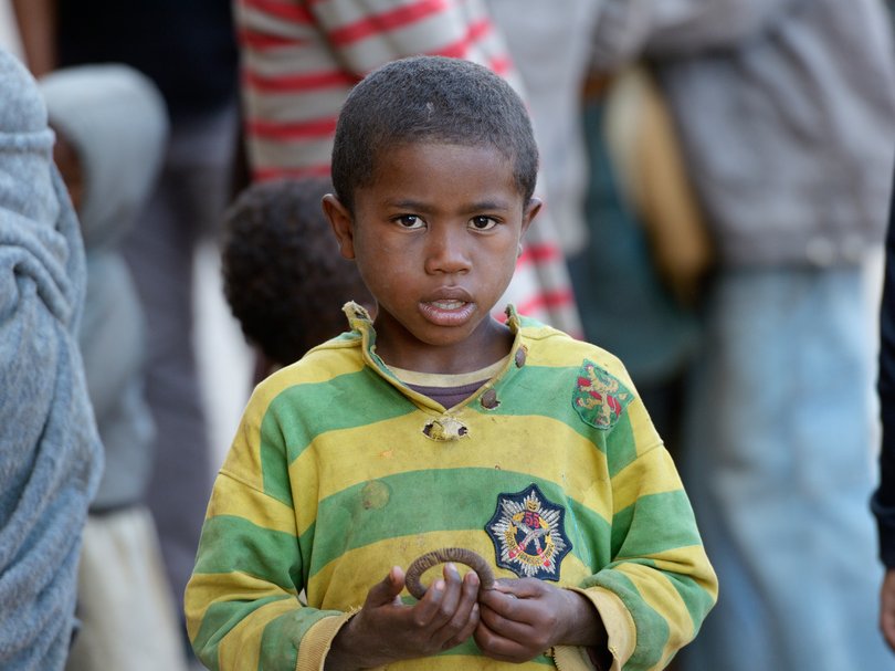 Kleiner Straßenjunge in einer Menge von Menschen