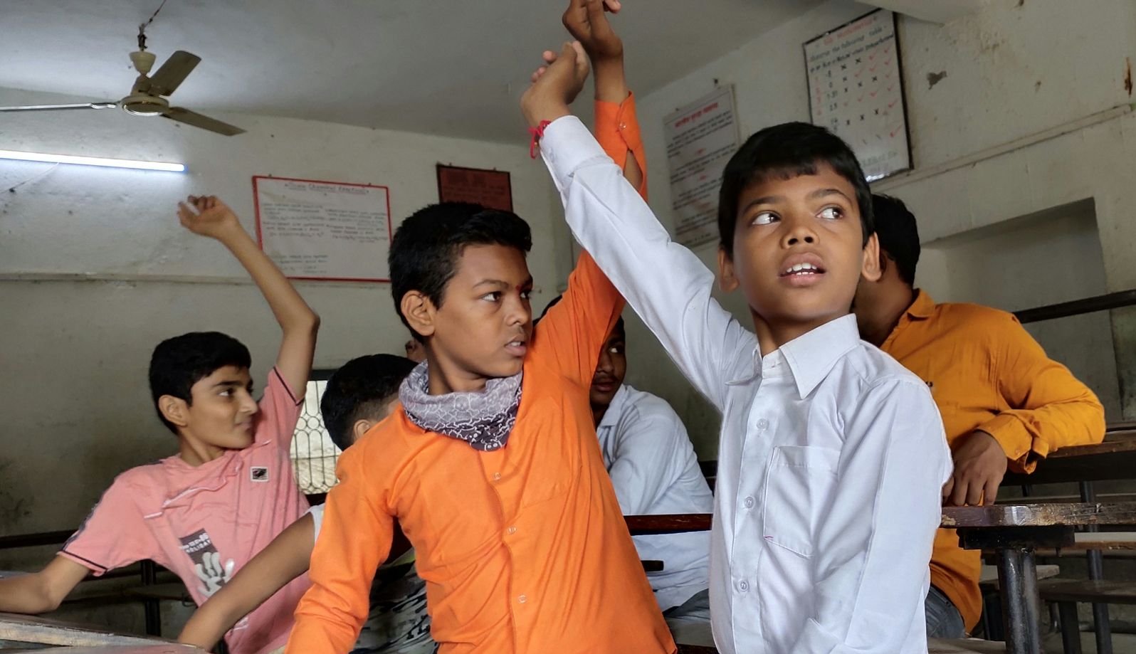 Kinder im Klassenzimmer haben Fragen an die Lehrerin