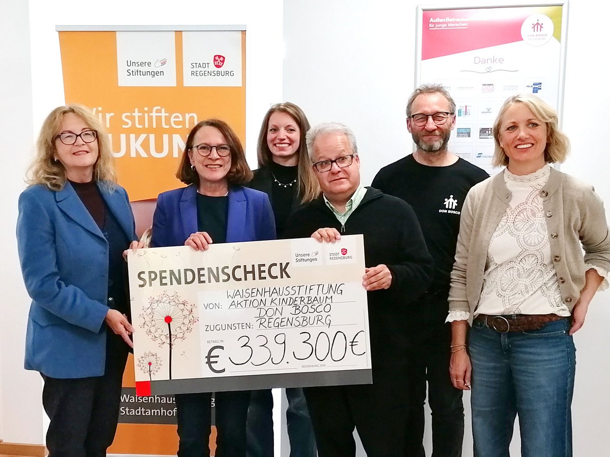 Sechs Personen halten Spendenscheck über 339.300 € von Waisenhausstiftung, Aktion Kinderbaum, Don Bosco, zugunsten Regensburg.