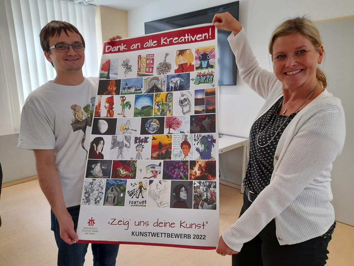 Zwei lächelnde Personen halten ein Poster mit einer Kunst-Collage des Wettbewerbs „Zeig uns deine Kunst“ 2022.
