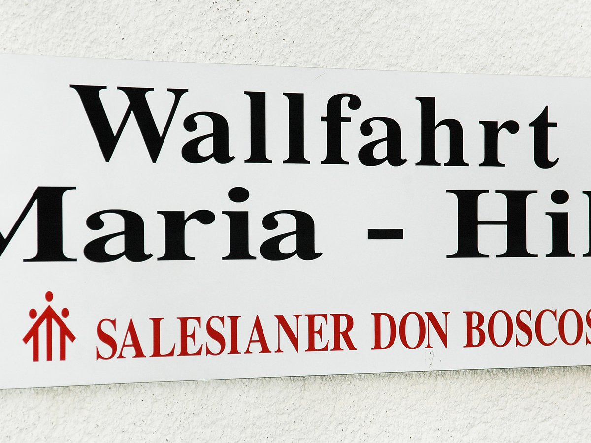 Schild mit der Aufschrift 'Wallfahrt Maria - Hilf' und 'Salesianer Don Boscos', inkl. rotem Salesianer-Logo.