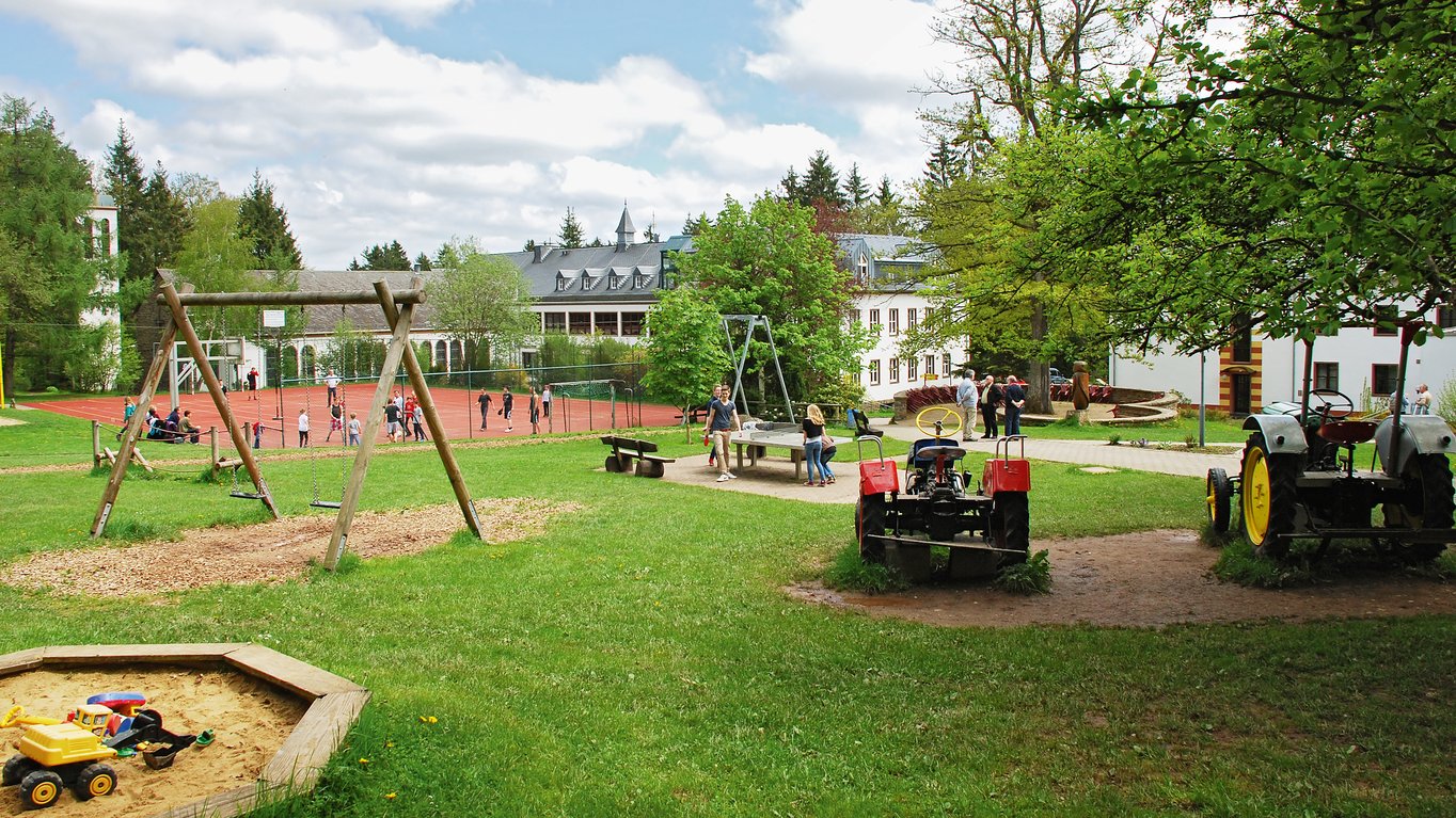 Spielplatz mit Schaukel und grüner Wiese