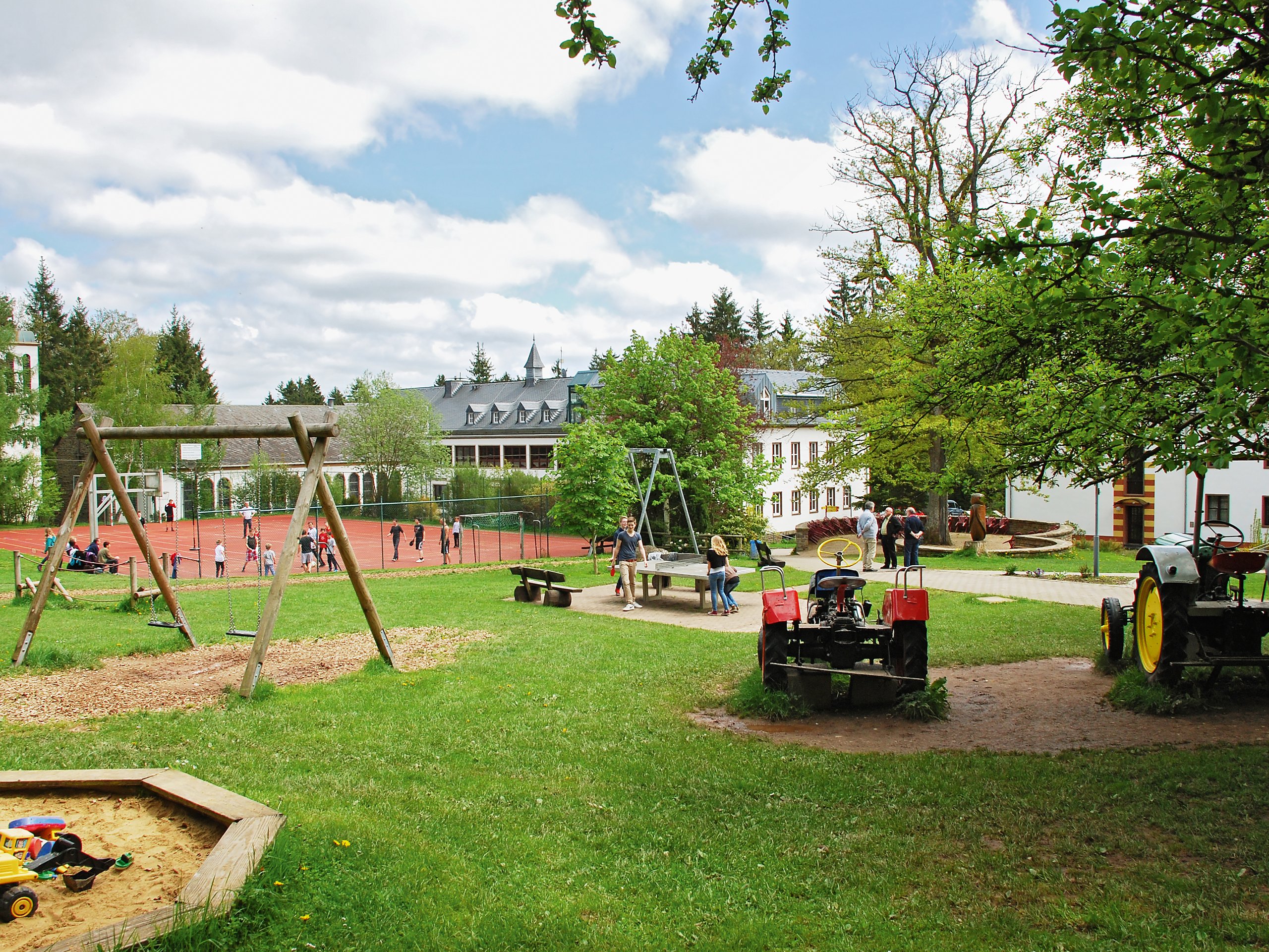 Spielplatz mit Schaukel und grüner Wiese