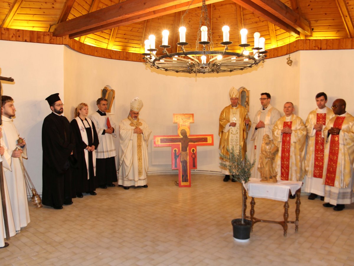 Eine Gruppe christlicher Geistlicher in zeremoniellen Gewändern, Priester und Bischöfe, versammelt in einem sakralen Raum.