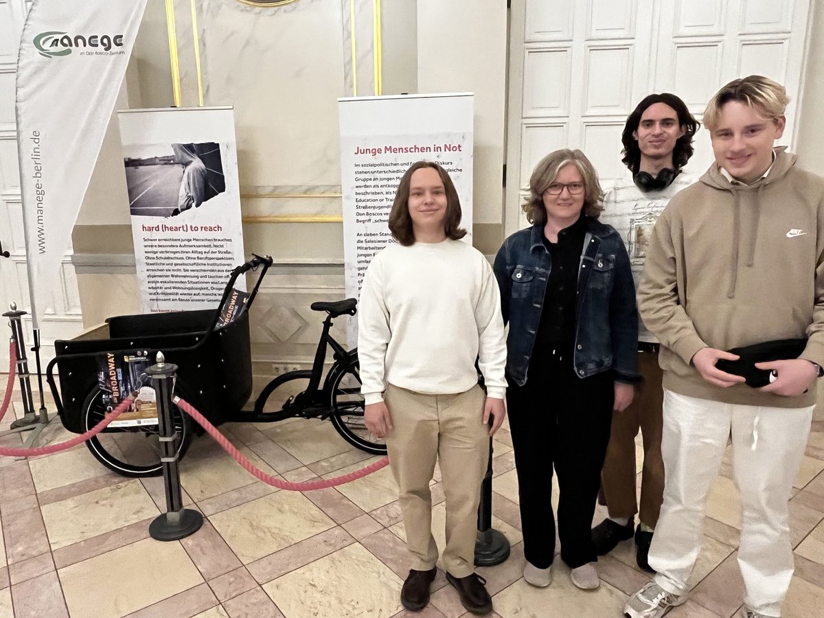 Gruppe von fünf Personen posiert mit Bannern und einem Lastenrad des Jugendhilfeprojekts 'manege-berlin'.