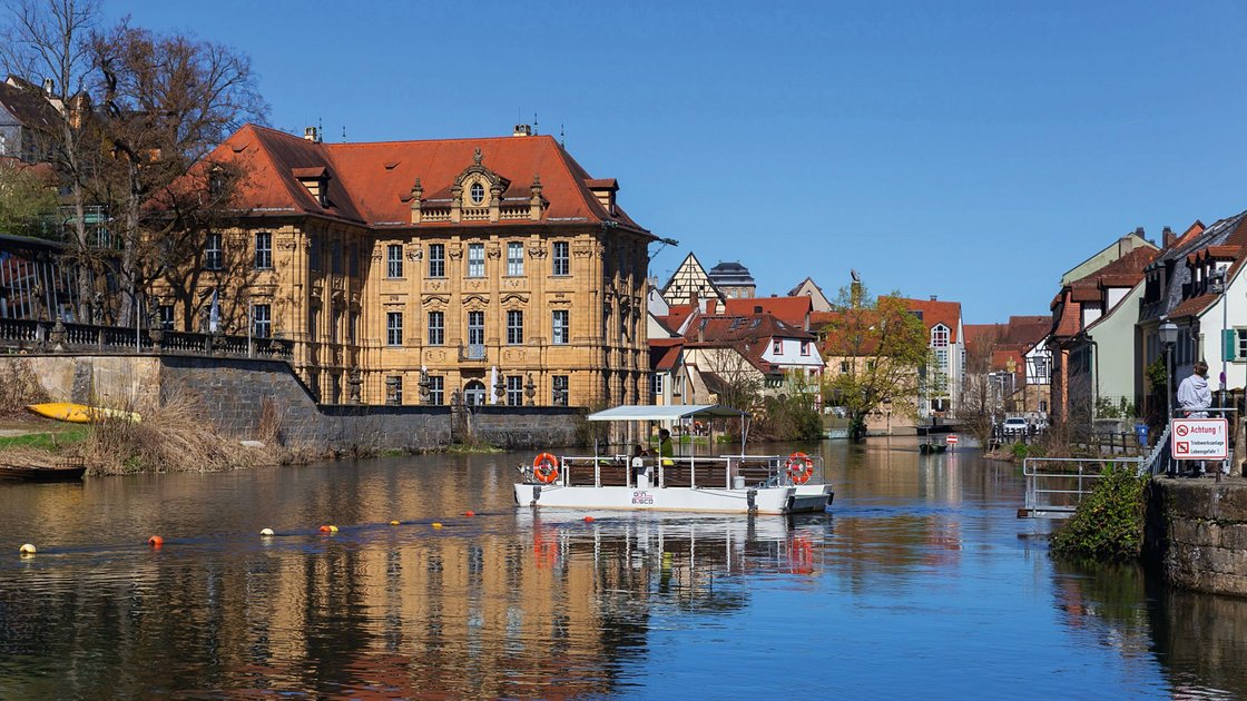 Fähre auf Fluss vor historischer Altstadt