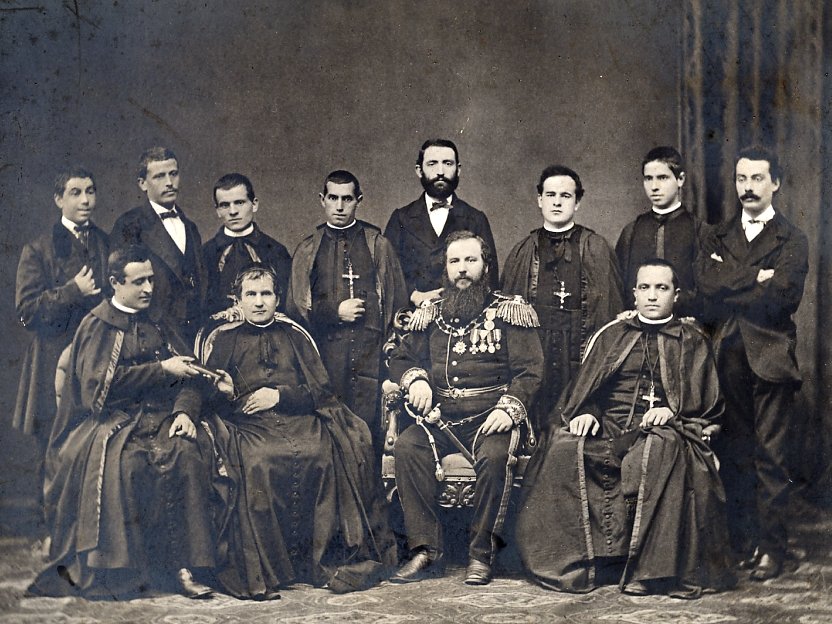 Gruppenporträt von zwölf Männern in gemischter Kleidung: Geistliche, Militär und Zivilisten, ca. Ende 19. Jh.