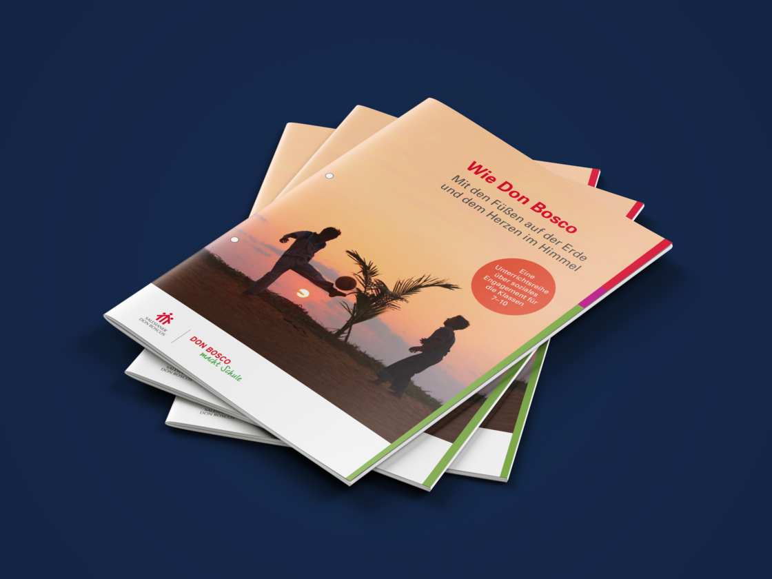Broschürenstapel. Das Cover der obersten Broschüre zeigt den Titel 'Wie Don Bosco' und Silhouetten, die bei Sonnenuntergang Ball spielen.