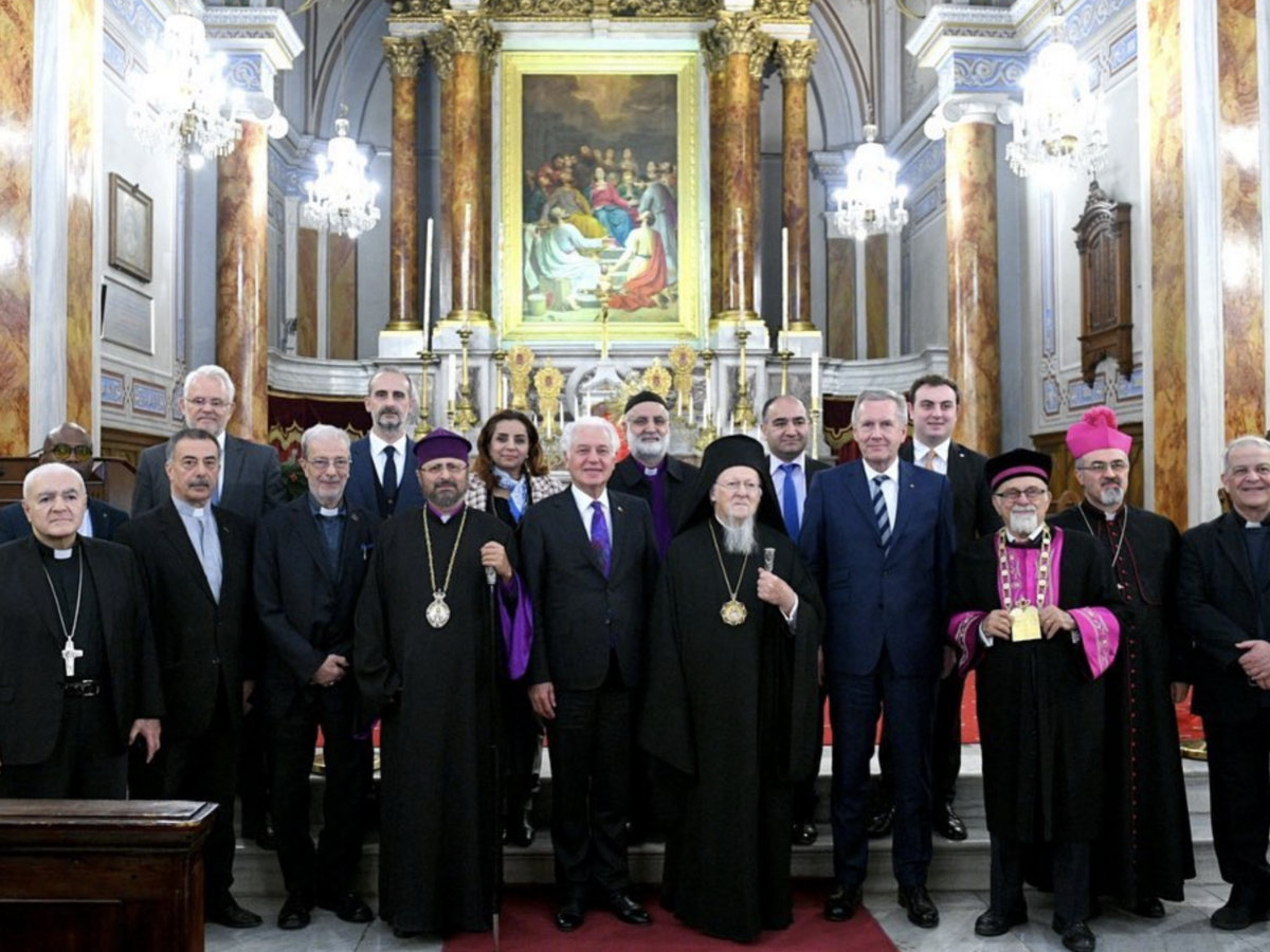 Gruppe von Religionsführern und Offiziellen, darunter Ökumenischer Patriarch Bartholomäus I., in einer reich verzierten Kirche.