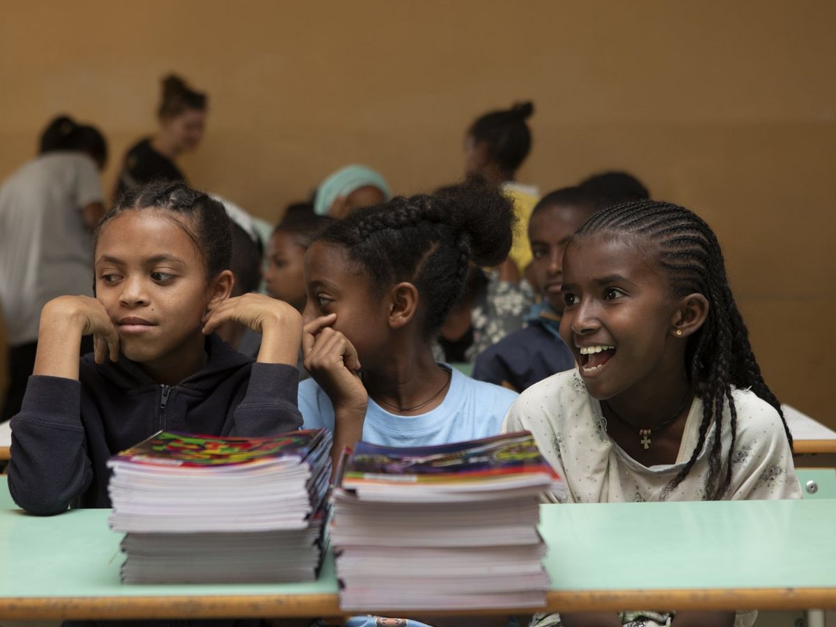 Schülerinnen im Klassenzimmer Drei junge Schülerinnen in einem Klassenzimmer. Eine lacht fröhlich, eine schaut nachdenklich und die dritte aufmerksam.