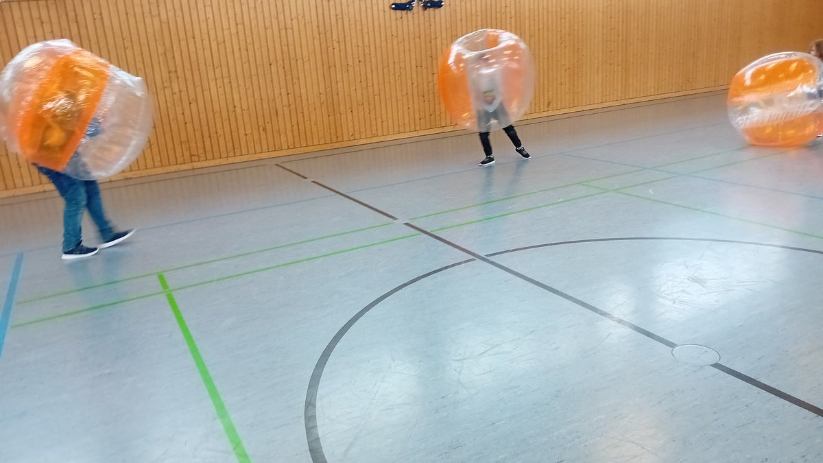 Kinder laufen in mit Luft gefüllten Plastikkugeln durch Sporthalle von Don Bosco Pfaffendorf 