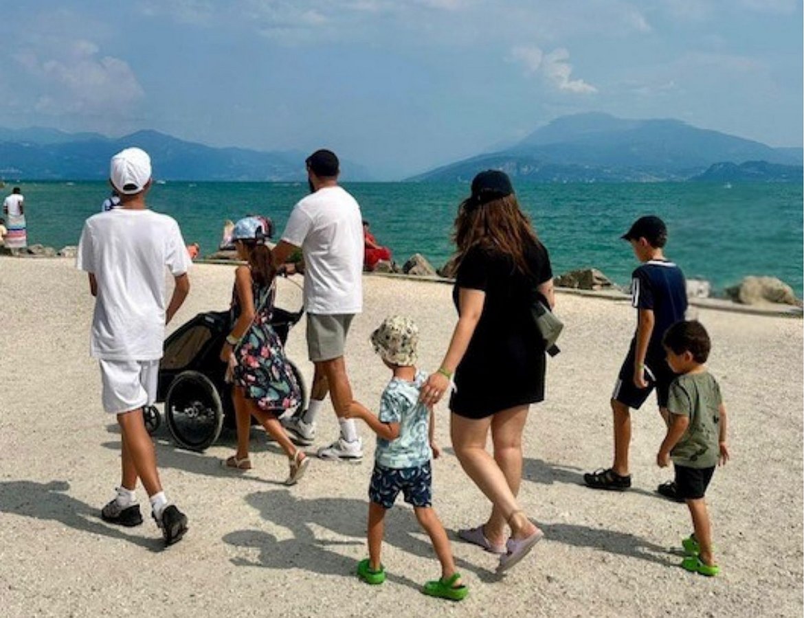 Kinder und Betreuer laufen auf Weg an See entlang