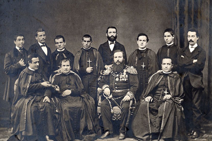 Historisches Gruppenporträt von Priestern und einem bärtigen, dekorierten Militäroffizier.