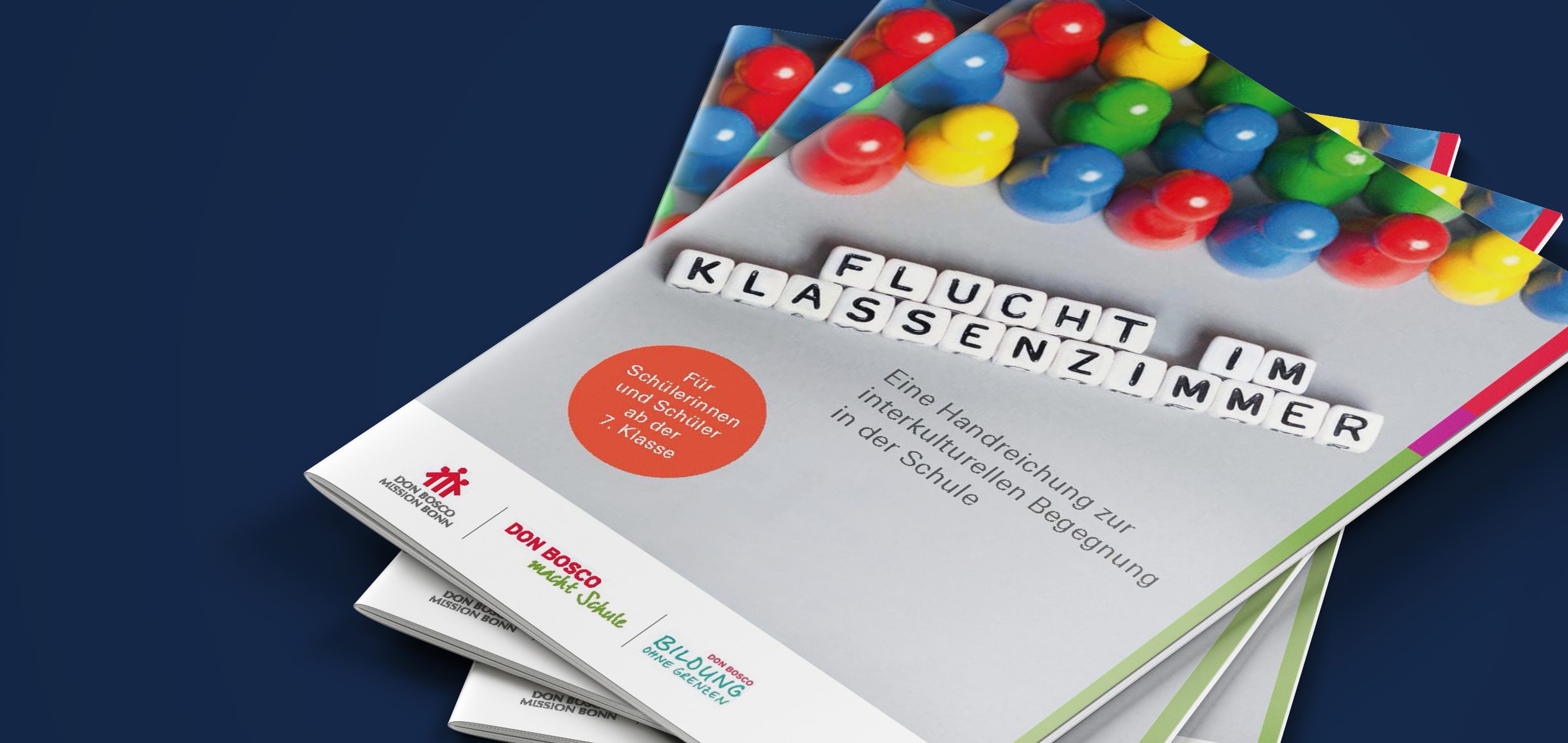 Stapel von drei Broschüren, die oberste zeigt den Titel 'FLUCHT IM KLASSENZIMMER' aus Buchstabenwürfeln mit Spielfiguren.