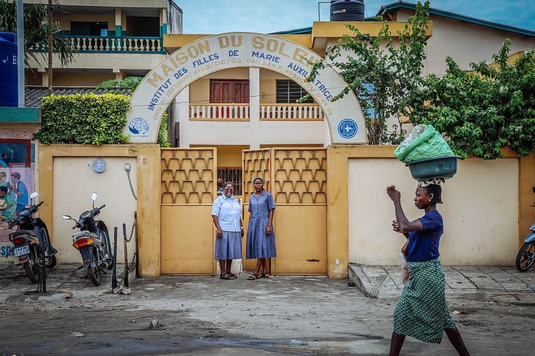 Menschen vor einem Hauseingang.
