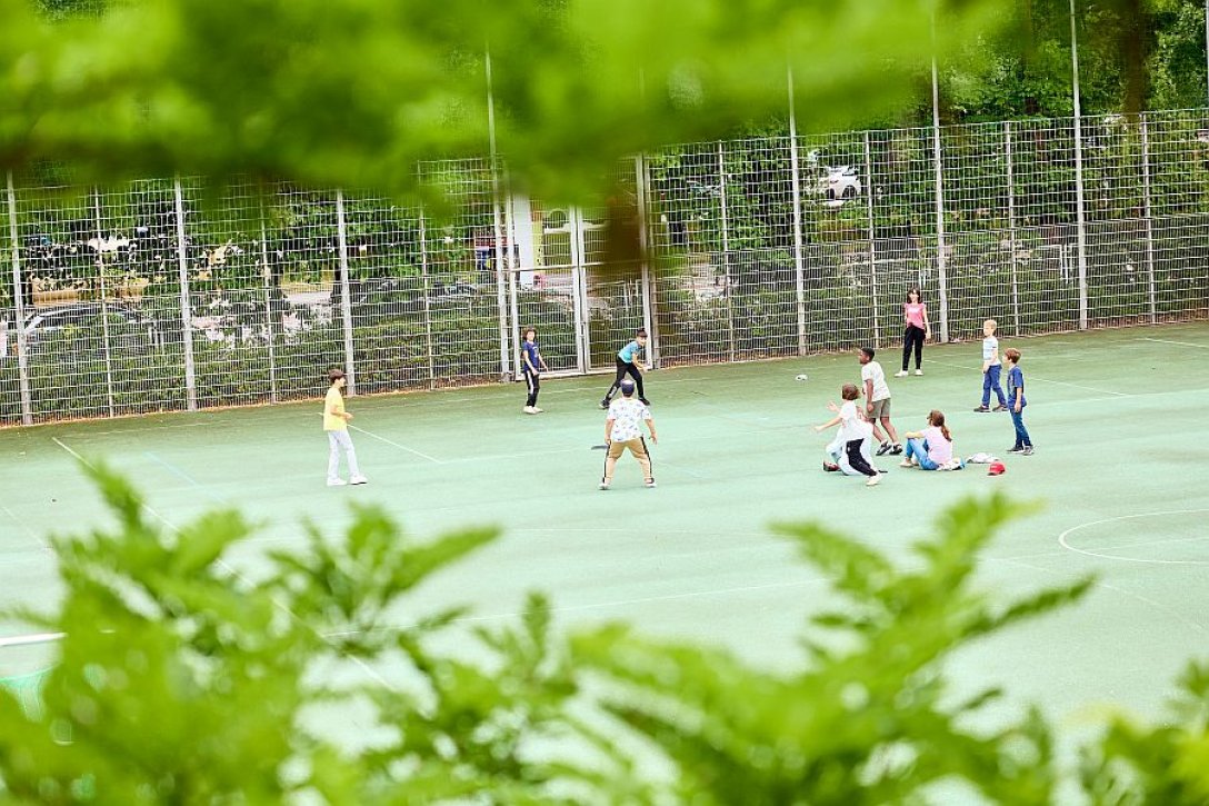 Kinder spielen auf dem Sportplatz.