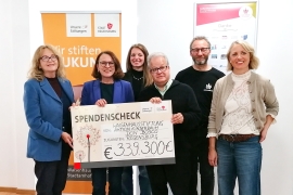 Vier Männer und zwei Frauen halten einen großen Spendenscheck in den Händen