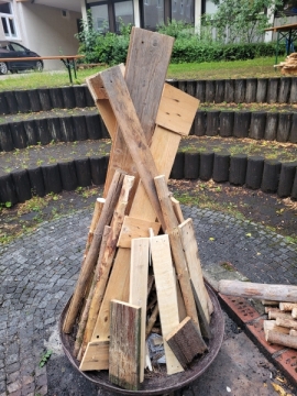 Im Innenhof des Salesianums sind Holzbretter in einer Feuerschale für das Sonnwendfeuer aufgeschichtet.