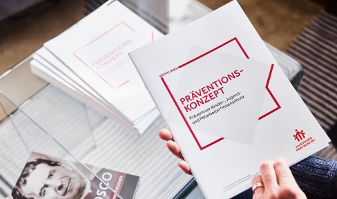 Das Pr&auml;ventionskonzept der Salesianer Don Boscos, im Hintegrund liegt ein Buch mit einem Bild Don Boscos.