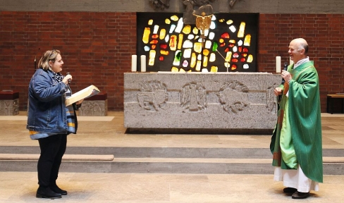 Frau und Priester im Altarraum einer Kirche 