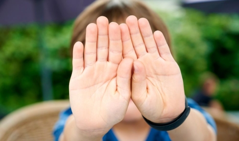 Kinderhände in Abwehrhaltung vor dem Gesicht