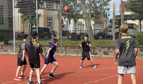 Jugendliche spielen Ball auf dem Sportplatz der Villa Lampe in Heiligenstadt 