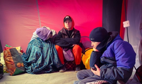 Zwei Kinder aus der Ukraine sitzen in einem Zelt, einer provisorischen Flüchtlingsunterkunft.
