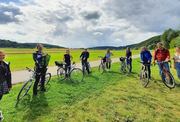 Mitarbeiter des Don Bosco Zentrum Regensburg mit Fahrrädern im Grünen.