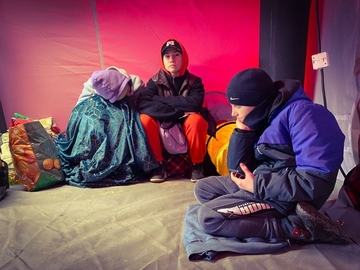 Zwei Kinder aus der Ukraine sitzen in einem Zelt, einer provisorischen Flüchtlingsunterkunft.