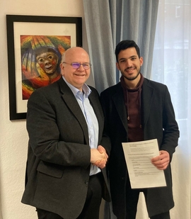 Der Schulleiter Lothar Hesse des Don Bosco Gymnaisums gratuliert Mohammed Al Ahmed zum Stipendium