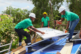 Mitarbeitende von Don Bosco Solar in Ghana bauen eine Solaranlage auf 